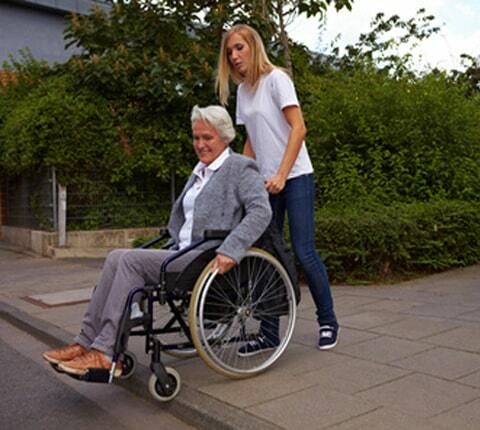 Senior resident in wheelchair receiving care in a UK nursing home